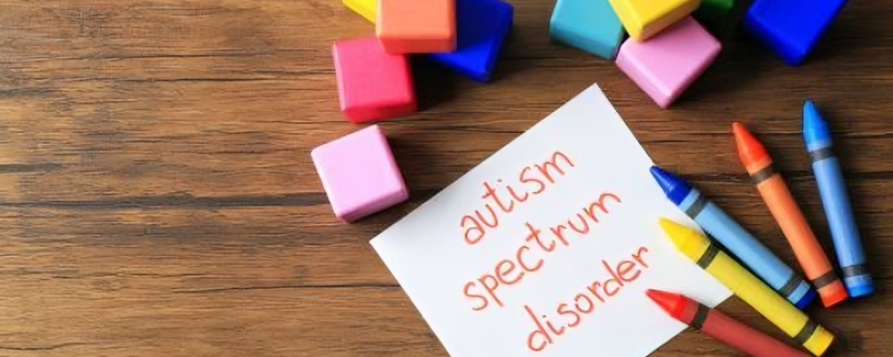 Colourful building blocks and crayons around a note reading Autism Spectrum Disorder.
